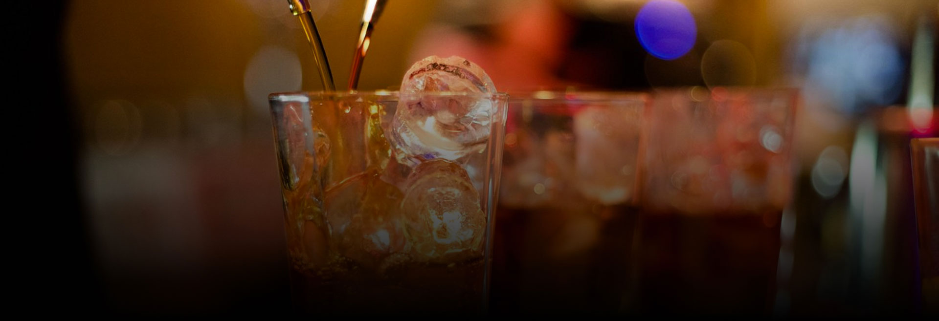 Barman versa una bevanda in un bicchiere con ghiaccio, creando un'atmosfera di festa e divertimento.