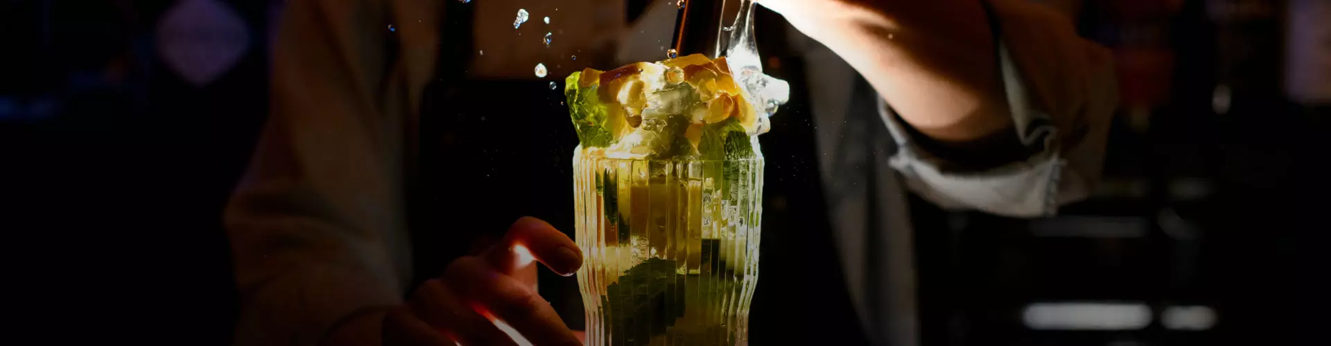 Un cocktail rinfrescante con frutta fresca e ghiaccio, mentre vengono aggiunti ingredienti, spruzzi d'acqua volano in alto.