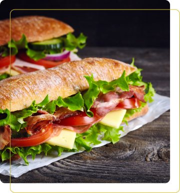 Panini farciti con lattuga, pomodoro, formaggio e bacon su un tavolo di legno scuro. Un'immagine invitante di due panini freschi.